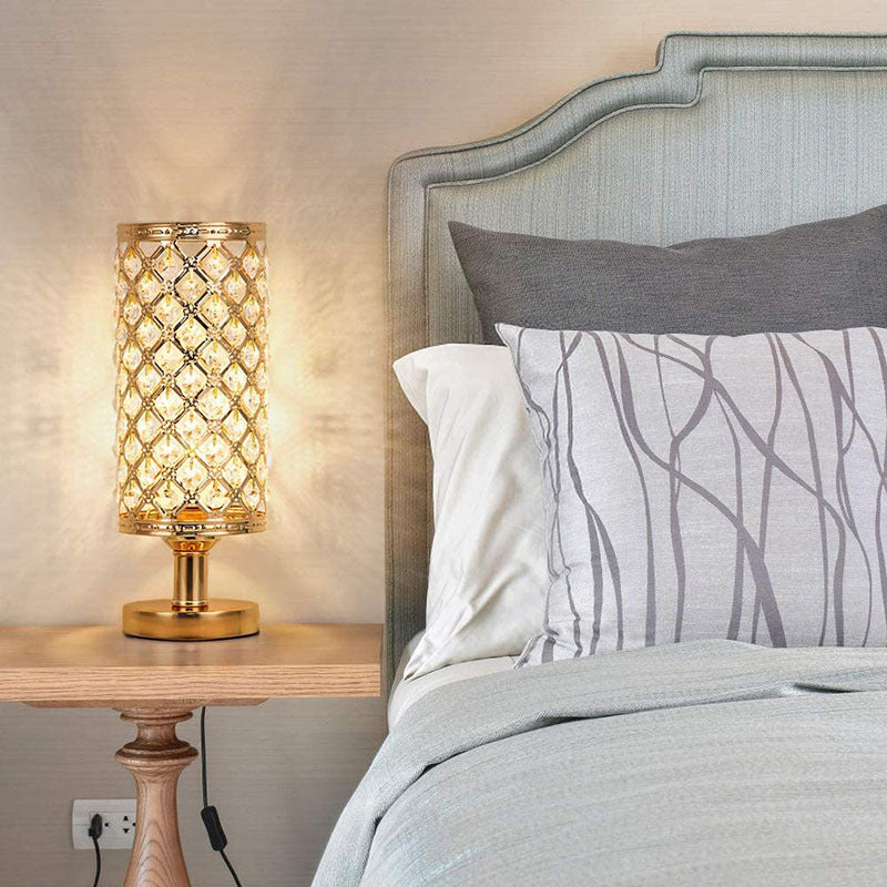 Decorative table lamp on a nightstand next to a bed with patterned bedding.