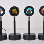 Four black stand-up lamps with colorful circular lights on a white background