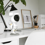 White astronaut figurine on a desk with office items in the background