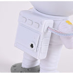 Close-up of a robot toy with a white body and gray base on a light gray background