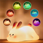 Cute rabbit-shaped night light with colorful projections on a warm background