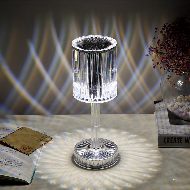Crystal-like table lamp on a reflective surface with blurred background