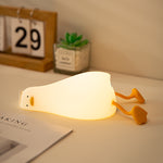 Light bulb-shaped night light on a desk with a calendar and plant in the background