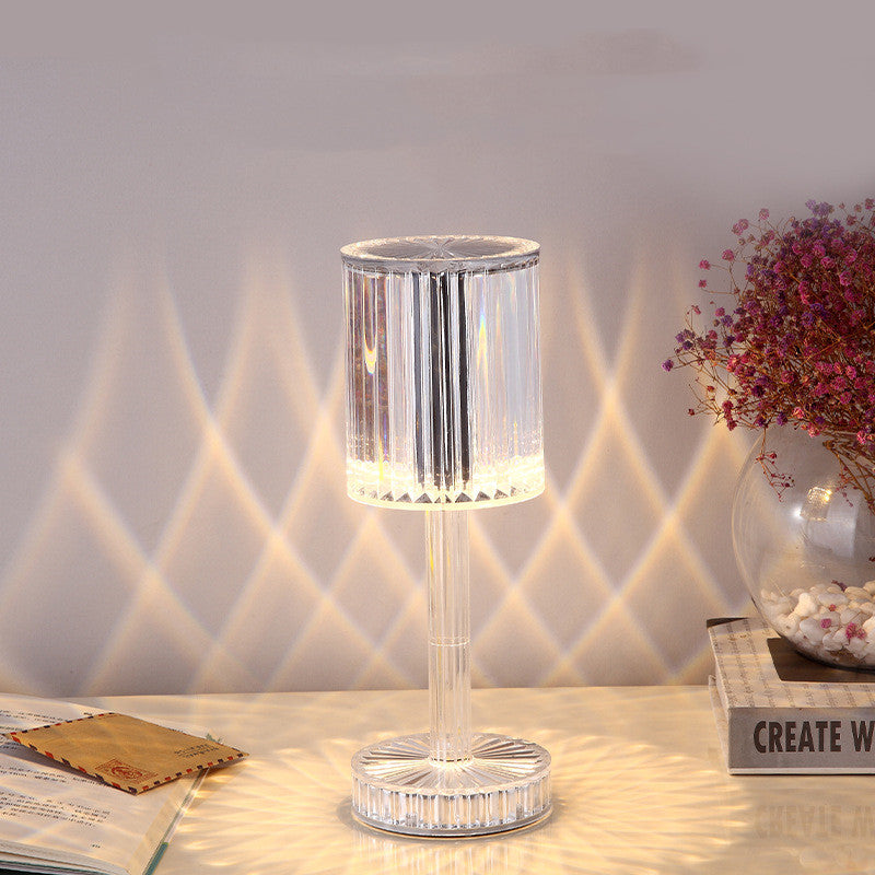 Crystal table lamp on a surface with decorative items in the background