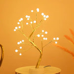 Decorative LED tree with white lights on a yellow background