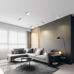 Modern living room with a gray sectional sofa, coffee table, and decorative elements.