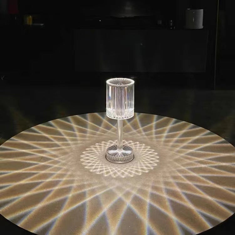 Glass goblet on a reflective surface with geometric light pattern