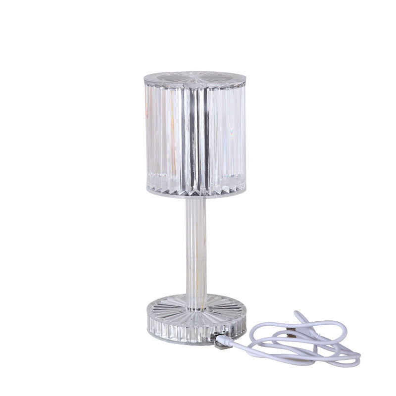 Clear glass table lamp with a white cord on a white background