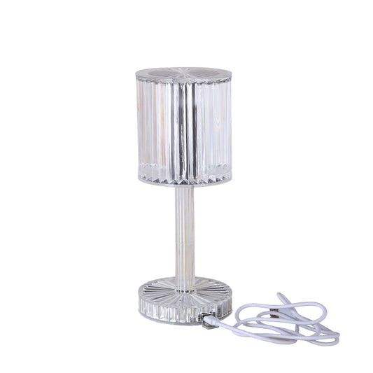 Clear glass table lamp with a white cord on a white background