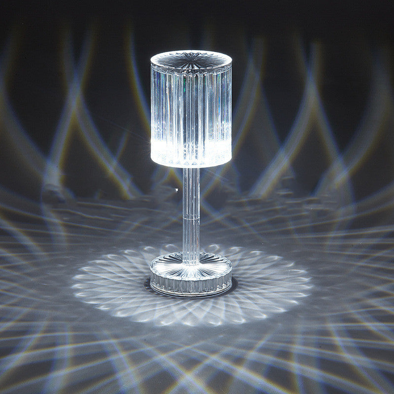 Clear glass table lamp with a unique design on a dark background