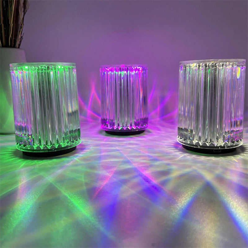 Three colorful LED lights on a reflective surface with multicolored reflections.