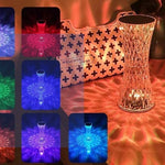 Decorative glass vase with colorful light patterns on a reflective surface, next to a patterned bag.