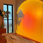 Room interior with a large window and a wall with a sunset design.