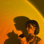 Woman holding a cat with a yellow textured background