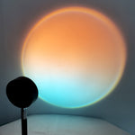 Colorful circular light projection on a wall with a black object in the foreground.